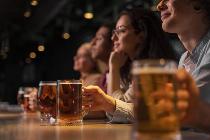 Close up friends holding beer mugs